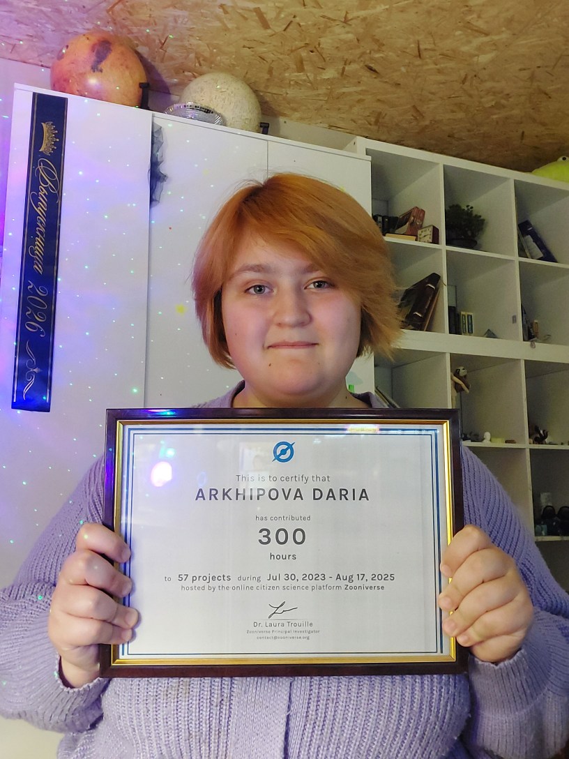 A 16 year old girl, Daria, holding Zooniverse certificate of participation.